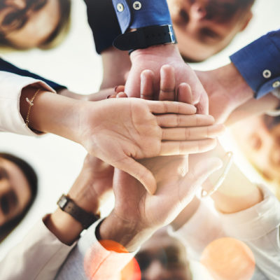 Cropped shot of a group of businesspeople putting their hands together in a huddle